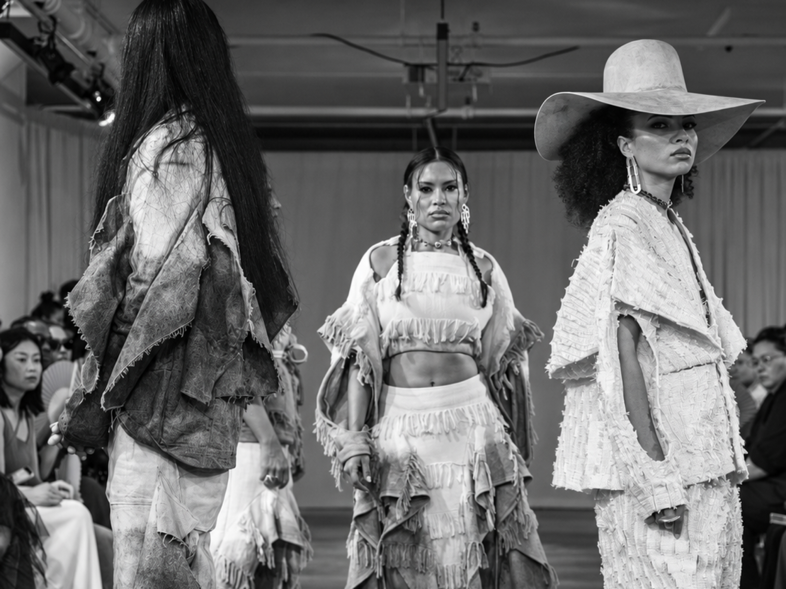 Models presenting monochrome fringed looks on a Fashion Week runway
