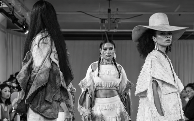 Models presenting monochrome fringed looks on a Fashion Week runway